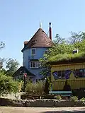 The Moomin house (in the background, blue) and Hemul's house (yellow, on the right)