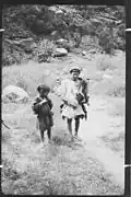 Urtsun (Utsun), Chitral, NWFP, Pakistan Kati boys, one dressed in a goat's skin with the typical Chitrali cap (pakol).