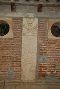 Detailed view of the second pillar of the ossuary: "MIRA CHRISTIANO QVE TV DIOS TE MIRA Y QVE AS DE SER CON RECTITVD JVZGADO SOCORRE A LAS ANIMAS Y SERAS DE DIOS PREMIADO"