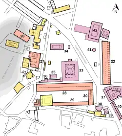Archaeological plan of a built-up area, with various numbered temples and other public buildings of classical to Roman era. There is a large hill to the west.
