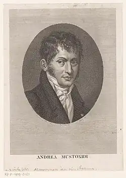 A young man in eighteenth-century formal dress, with untidy dark hair and sideburns.