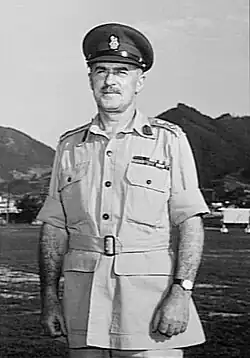 Outdoor half-portrait of moustachioed man in summer military uniform with peaked cap