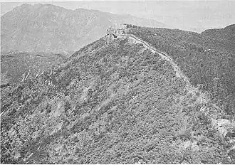 A hill top lined with stone walls and crumbling fortifications