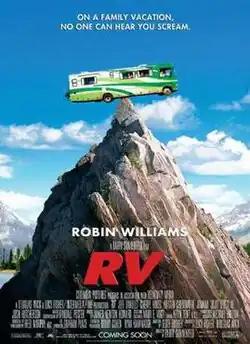 A green Recreational vehicle (RV) perched precariously on a mountain peak.