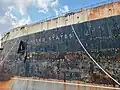 The rusting ship's name and bow.