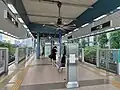 The island platform of Layar station with ventaliation fans. Platform barriers minimise commuters' access to the tracks.