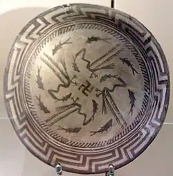 Samarra plate, with a design consists of a rim, a circle of eight fish, and four fish swimming towards the center being caught by four birds, at the center being a swastika symbol; circa 4000 BCE; painted ceramic; diameter: 27.7&nbsp;cm; Vorderasiatisches Museum (Berlin)