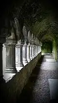 A dark barrel-vaulted corridor with an arcade on the left