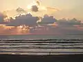 A person taking an early morning walk on the Gulf side of the island
