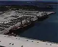 Ex-RVNAF A-37s and Hueys on a pier at Naval Base Guam