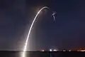 A long-exposure photo shows lift off, second stage ignition, and first stage boostback
