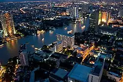 Night view showing the Bang Rak area on the near side of the river