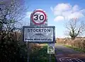 The sign on the road from Napton; note the image of an ichthyosaurus