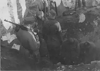 NARA copy #20, IPN copy #19 A bunker being opened Stroop witnesses digging out of a bunker, possibly near the ghetto wall. 8 May 1943