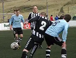 Image 22TB Tvøroyri is the oldest football club of the Faroe Islands, it was founded in 1892. Óli Johannesen (in black/white) holds the record for most capped player of the Faroe Islands national football team. Here TB plays against Víkingur Gøta. (from Culture of the Faroe Islands)