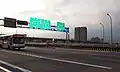 The main Taipei Bridge automobile bridge approaching Sanchong (三重) just before the exit ramp for Huánhé Road (環河北路) in 2008 The bridge in the background above Taipei Bridge is the Huánhé Expressway (環河快速道路)