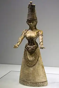 Minoan statue of a woman with bare breasts, her hands outstretched with snakes running along each arm