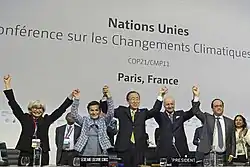 Several persons holding hands together upraised on a stage