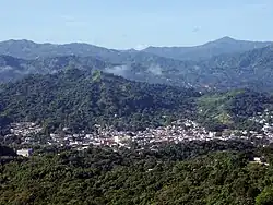 Large green mountain dotted with homes