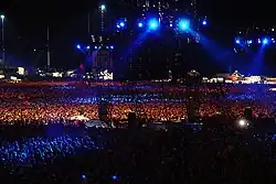 Darkened stadium concert, with blue lights