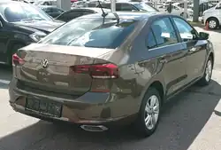 Rear-three-quarter view of a four-door car with a three-box body style whose luggage compartment is separate from the passenger cockpit.