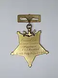 Back side of Pelham's medal with engraved text