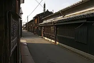 A small street lined by wooden two-storied houses.