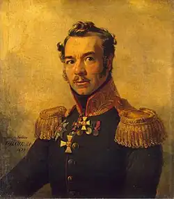 Portrait of a man with a moustache wearing a dark, high-collared military uniform.