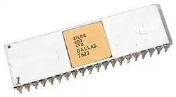 A close-up of a silver computer chip with a gold square on a white background. The chip has text on it that says "ZILOG Z80 CPU DALLAS 7623".